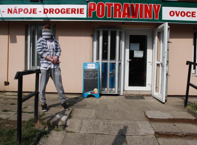 jeden z pachatelů před přepadenou prodejnou